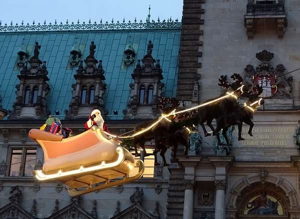 Der Weihnachtsmann fliegt in seinem Schlitten über den Weihnachtsmarkt vor dem Hamburger Rathaus